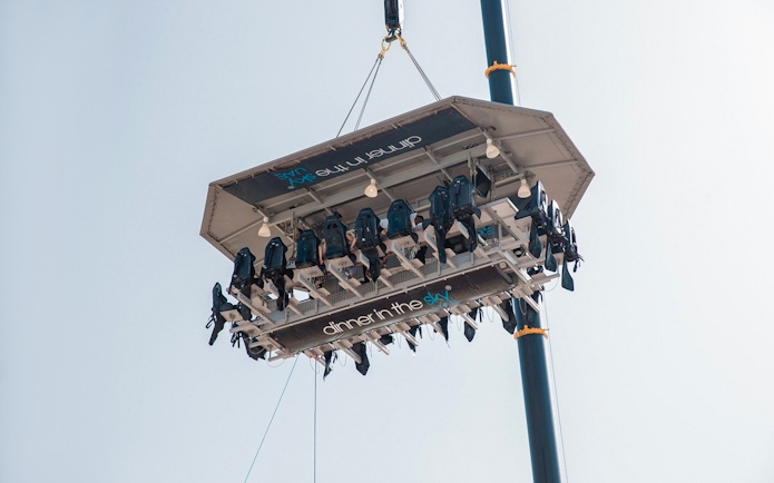 Guests dining on a suspended platform for Dinner in the Sky experience.