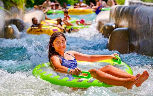 Tubing adventure at The Falls, Schlitterbahn New Braunfels, with people enjoying the water ride.