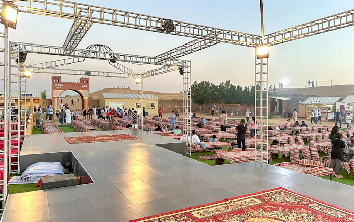 Evening desert safari setup with seating and stage in Dubai.