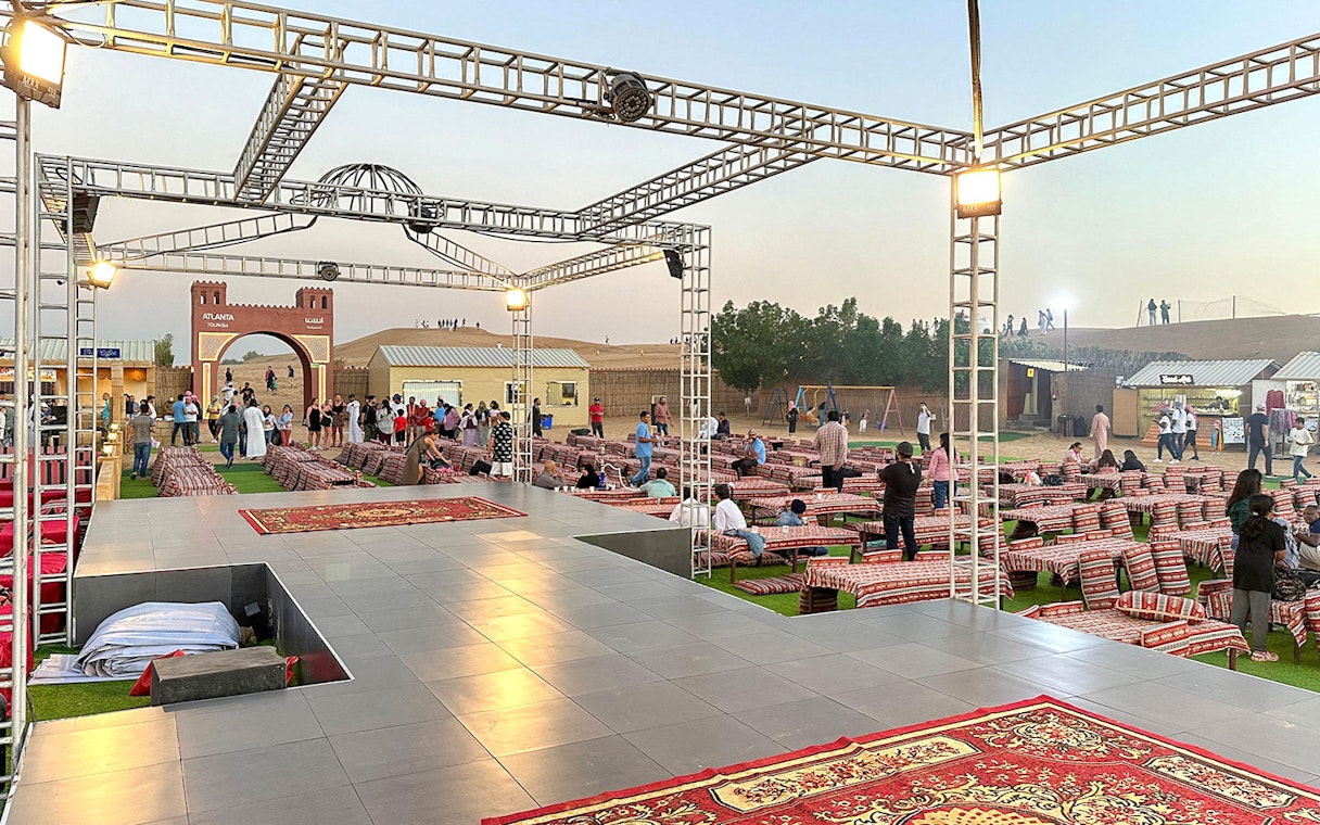 Evening desert safari setup with seating and stage in Dubai.