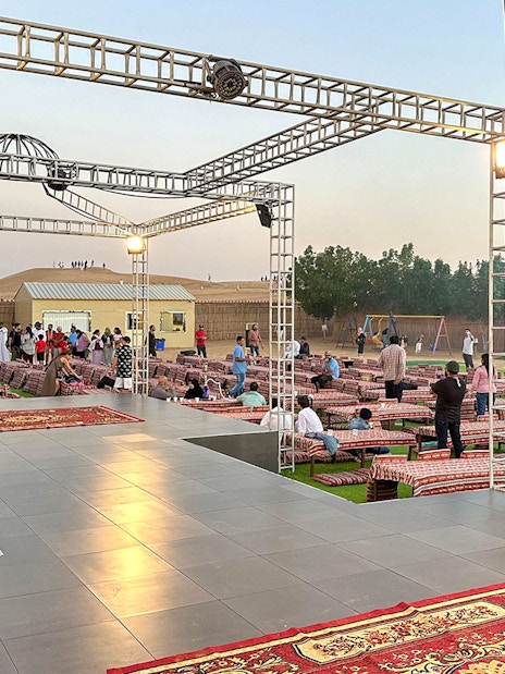 Evening desert safari setup with seating and stage in Dubai.