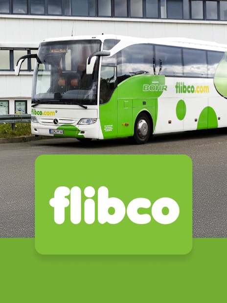 Flibco bus parked near a building, offering transfers between London Stansted Airport and London City.
