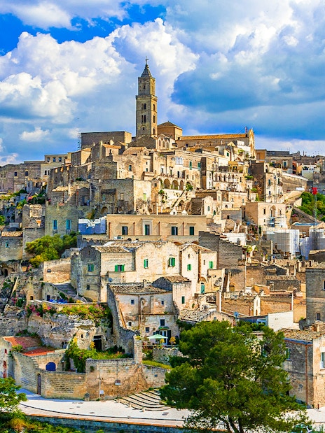 Sassi of Matera ancient stone buildings under a blue sky, Italy.