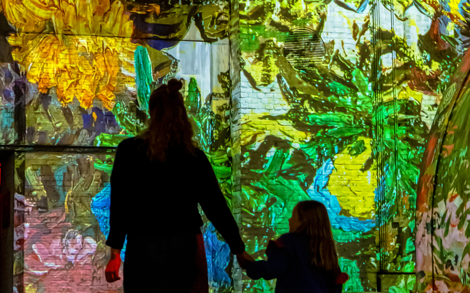 Visitors enjoying immersive art projections at Fabrique des Lumières.