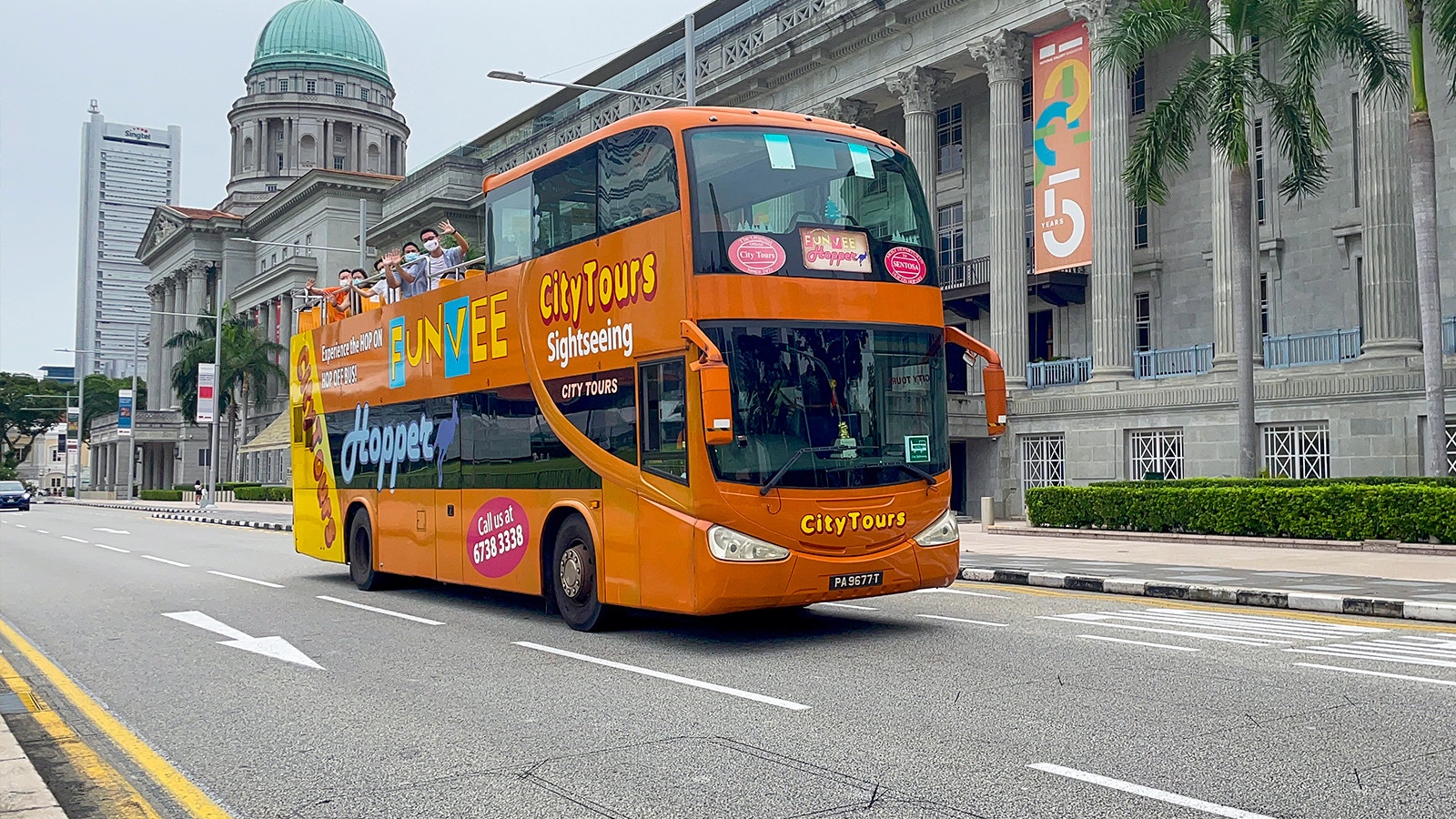 Open-top bus touring Singapore cityscape with iconic skyline views.
