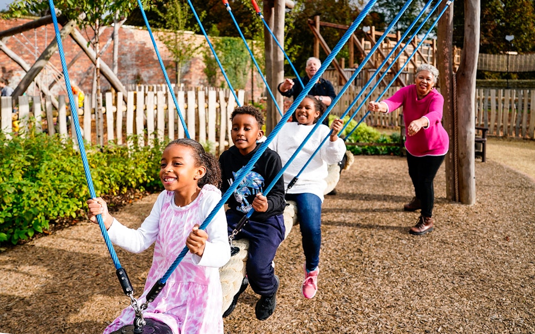 Children playing on swings at the adventure play area in Blenheim Palace.