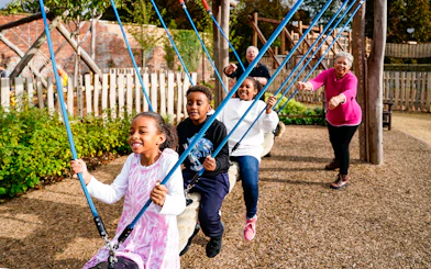 Children playing on swings at the adventure play area in Blenheim Palace.