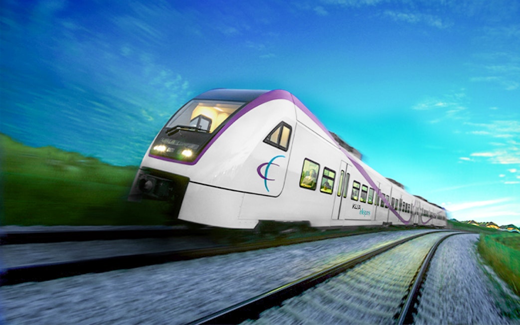 KLIA Ekspres train traveling on tracks under a clear blue sky.