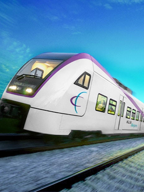 KLIA Ekspres train traveling on tracks under a clear blue sky.