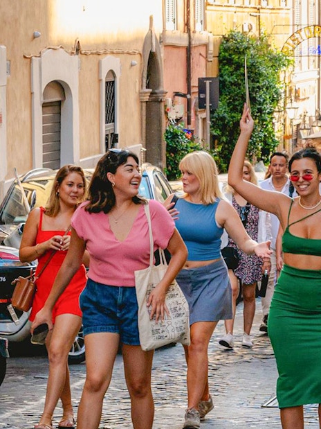 Tourists walking on a cobblestone street in Rome.