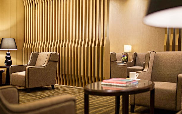 Plaza Premium First lounge seating area with modern decor and ambient lighting.