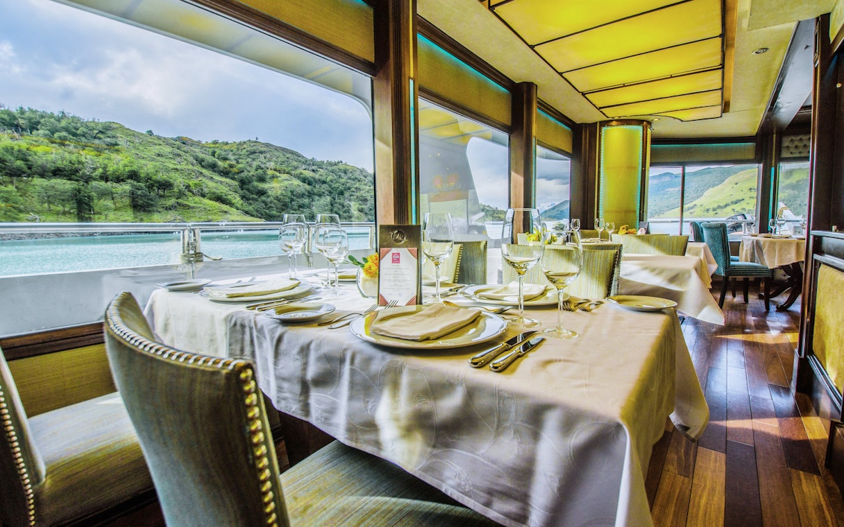 Dining area inside the boat with table settings during Spirit of the Glaciers tour.