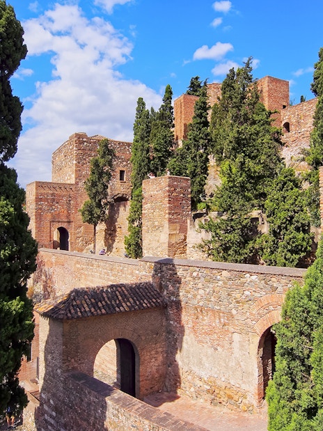 Roman Theater and Alcazaba Castle walls surrounded by lush greenery in Málaga, Spain.