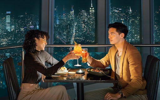 Couple dining with city skyline view at One World Observatory, New York City.