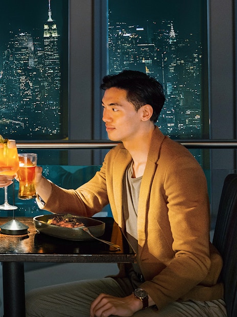 Couple dining with city skyline view at One World Observatory, New York City.