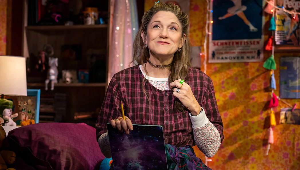Person in a cozy room holding a pencil and notebook, related to Kimberly Akimbo.