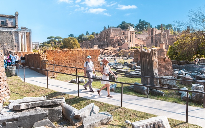 Visitors walking through the Roman Forum ruins in Rome.