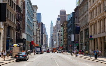 Busy New York City street with historic buildings, part of a self-guided superhero exploration game.