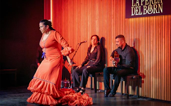Flamenco dancer performing at La Perla del Born in Barcelona with musicians.
