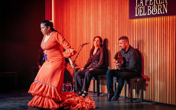 Flamenco dancer performing at La Perla del Born in Barcelona with musicians.