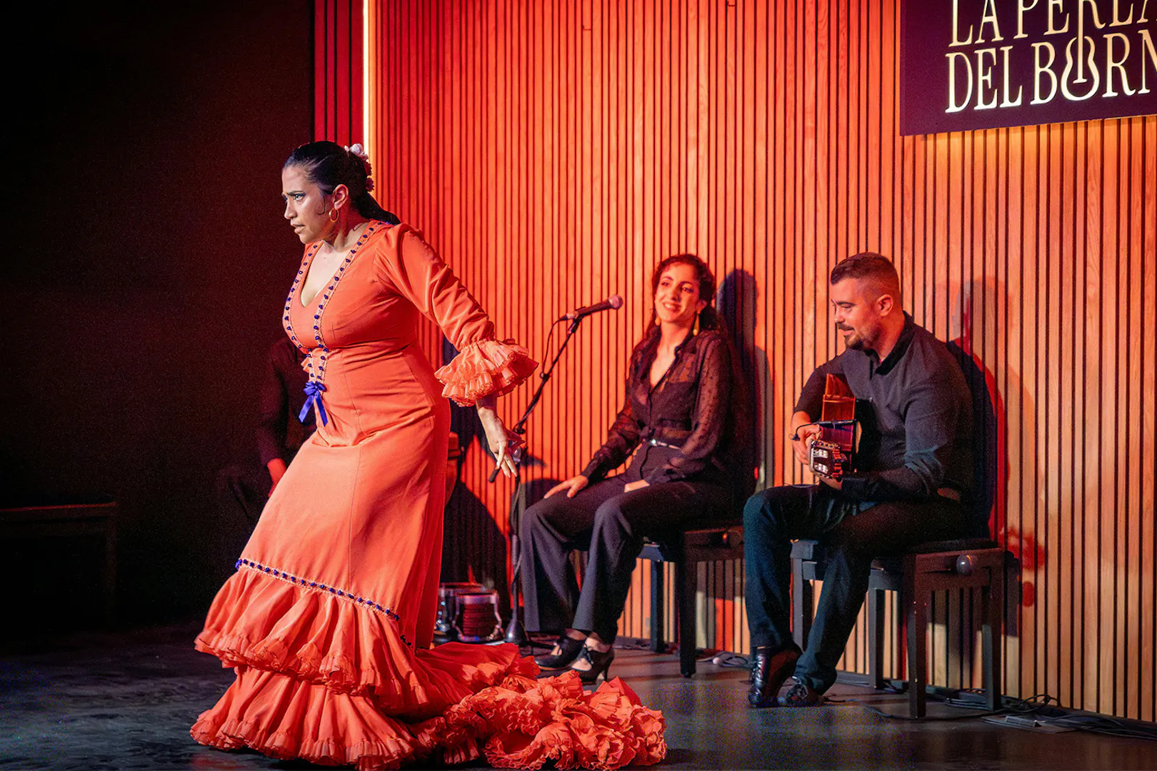 Flamenco dancer performing at La Perla del Born in Barcelona with musicians.