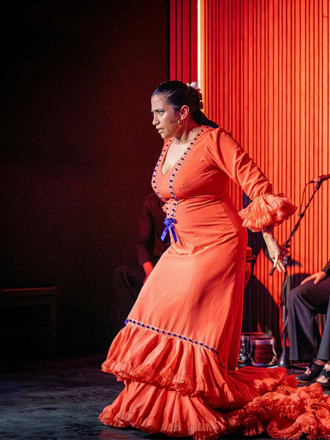 Flamenco dancer performing at La Perla del Born in Barcelona with musicians.