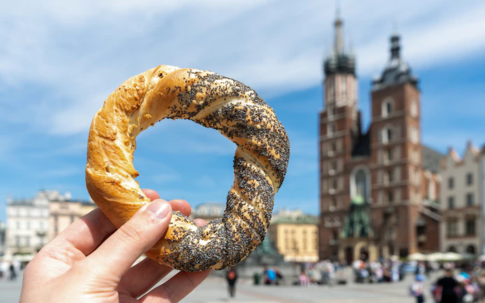 Kraków street food pretzel held in front of St. Mary's Basilica.