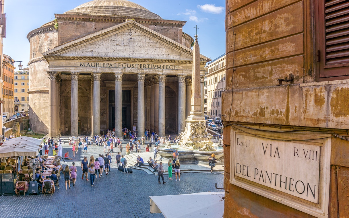 Pantheon in Rome with tourists and fountain in the foreground.