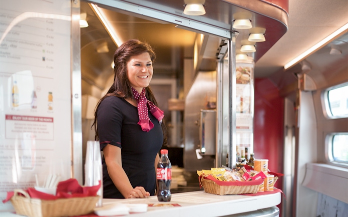 Train attendant serving snacks and drinks on an Interrail Global Mobile Pass Flex journey.