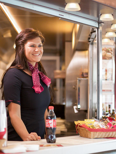 Train attendant serving snacks and drinks on an Interrail Global Mobile Pass Flex journey.