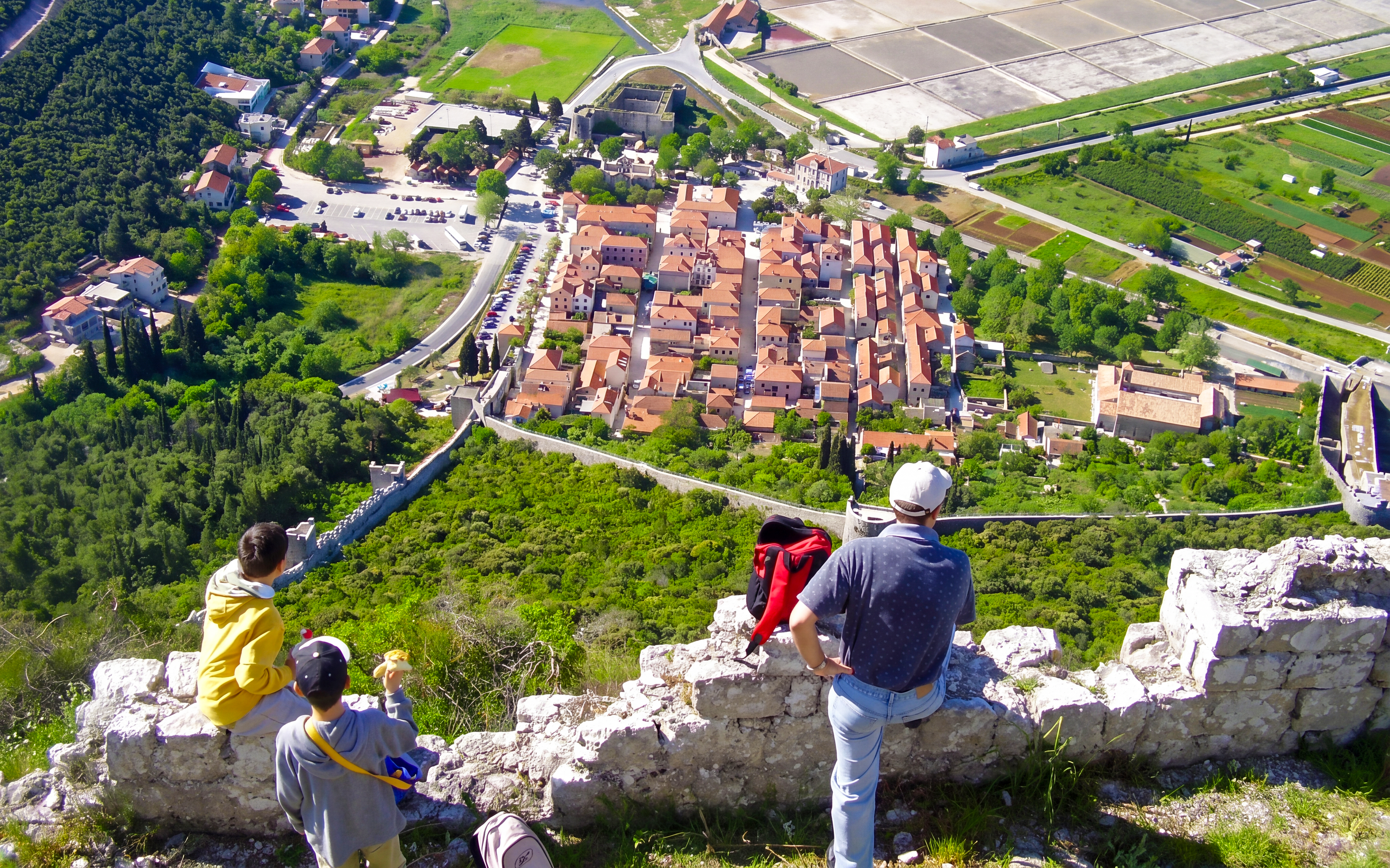 Family overlooking Ston, Croatia from a hilltop viewpoint.