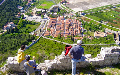 Family overlooking Ston, Croatia from a hilltop viewpoint.