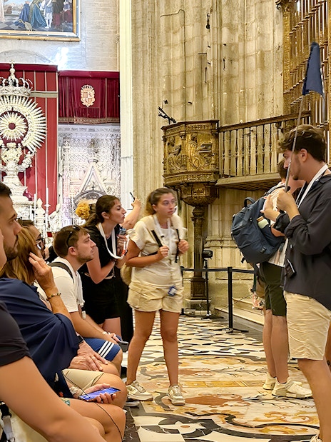 Tour group listening to a guide inside Seville Cathedral.