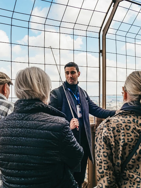 Tour guide explaining to a group on the Eiffel Tower's viewing platform, Paris.
