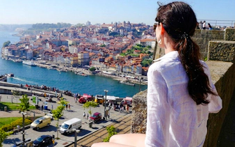 Person overlooking the Douro River and Porto cityscape in Portugal.