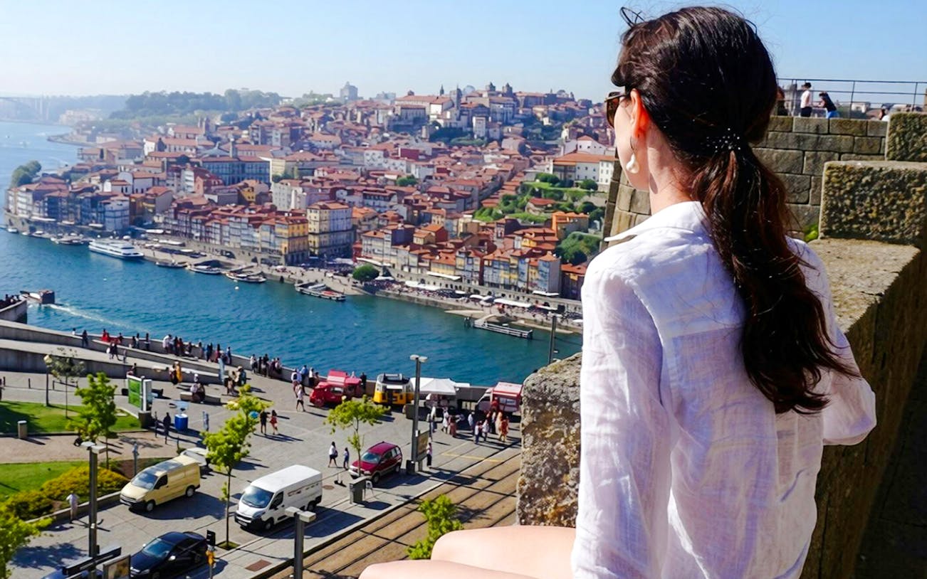 Person overlooking the Douro River and Porto cityscape in Portugal.