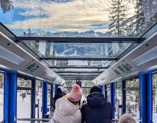 Couple enjoying mountain views inside Zakopane cable car.
