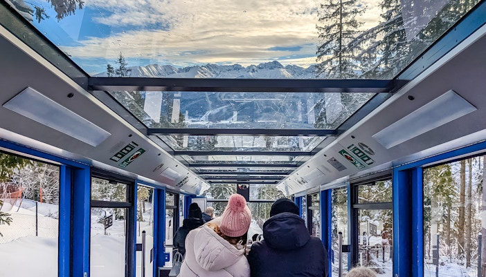 Couple enjoying mountain views inside Zakopane cable car.
