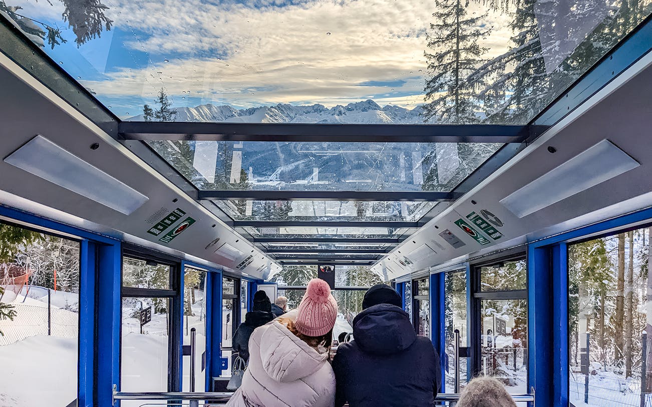 Couple enjoying scenic view inside Zakopane cable car, Poland.