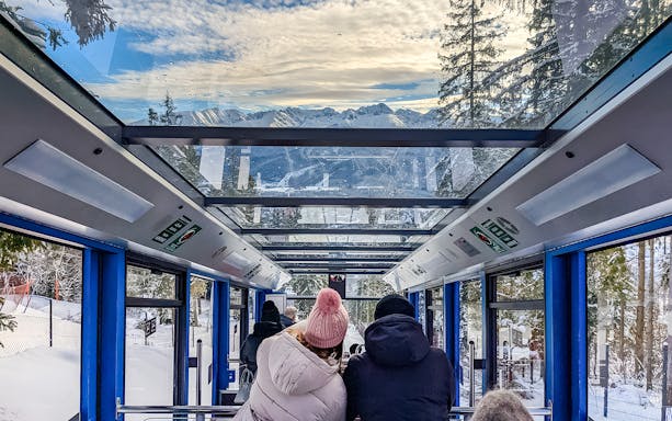 Couple enjoying mountain views inside Zakopane cable car.