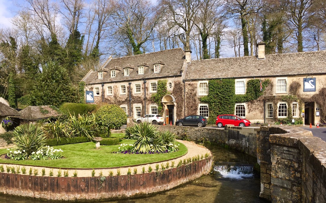 Cotswolds stone building with ivy, garden, and stream in front, near Broadway Tower, England.