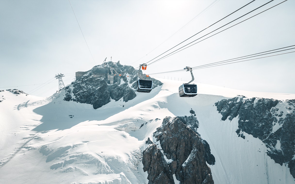 Cable car ascending Matterhorn Glacier Paradise with snowy peaks.
