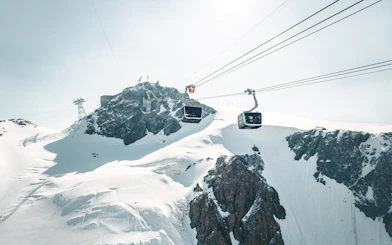 Cable car ascending Matterhorn Glacier Paradise with snowy peaks.