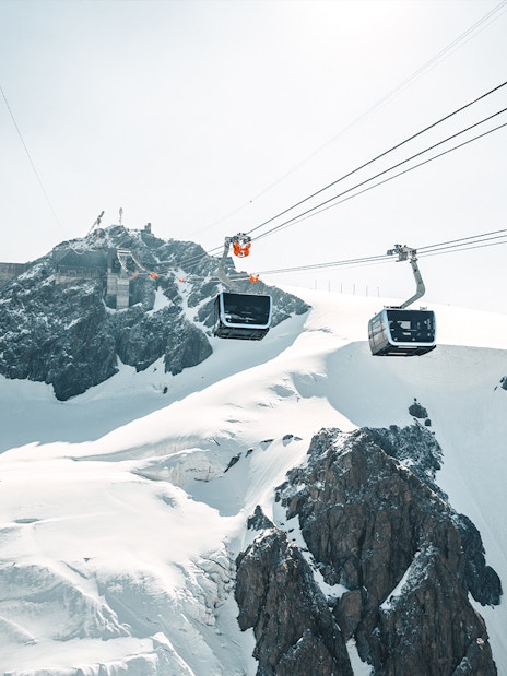 Cable car ascending Matterhorn Glacier Paradise with snowy peaks.