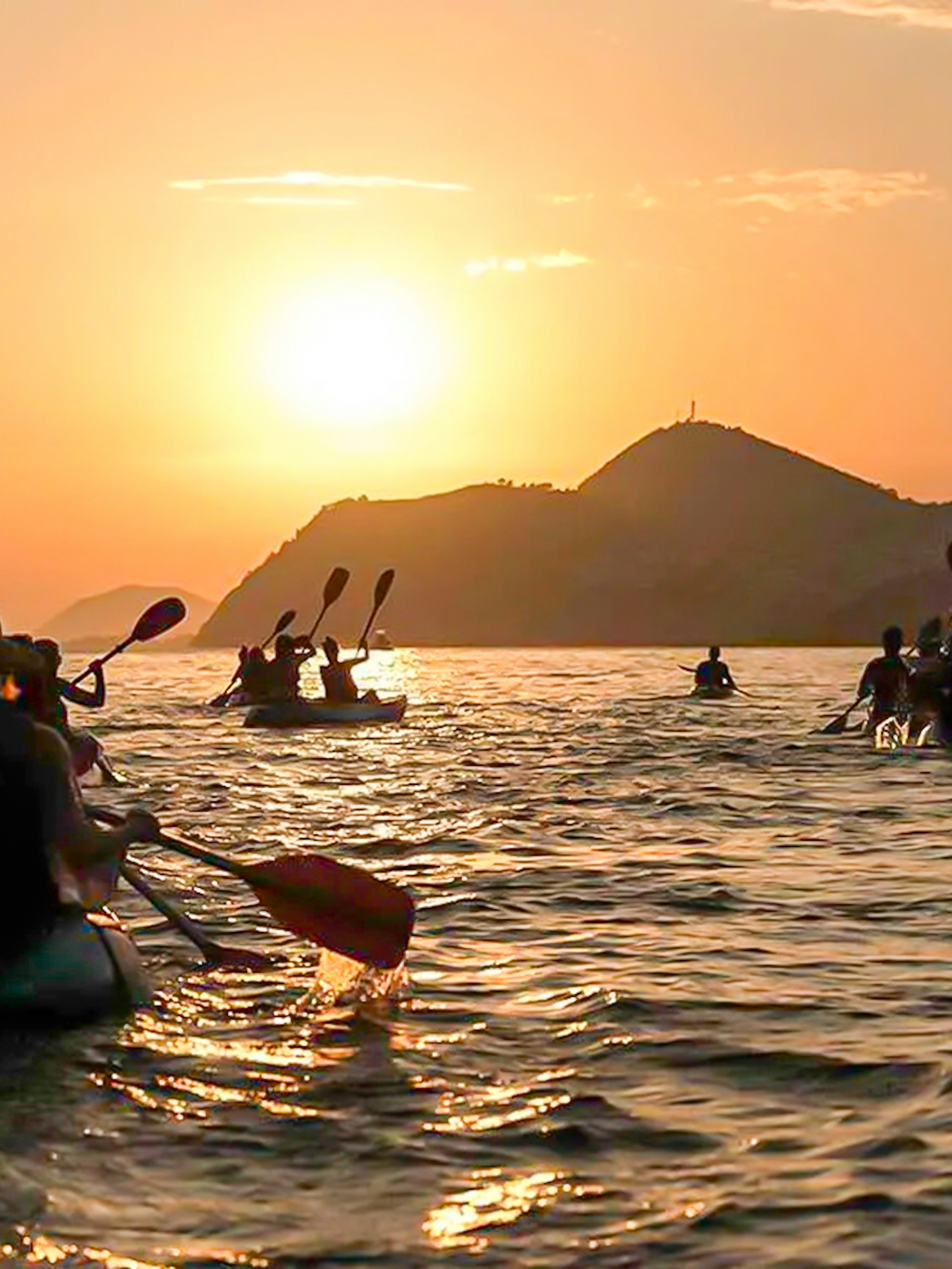 Kayakers paddling at sunset near Dubrovnik.