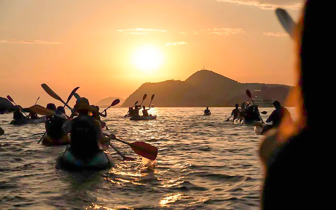 Kayakers paddling at sunset near Dubrovnik.