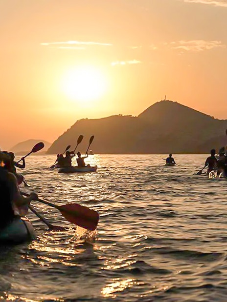 Kayakers paddling at sunset near Dubrovnik.