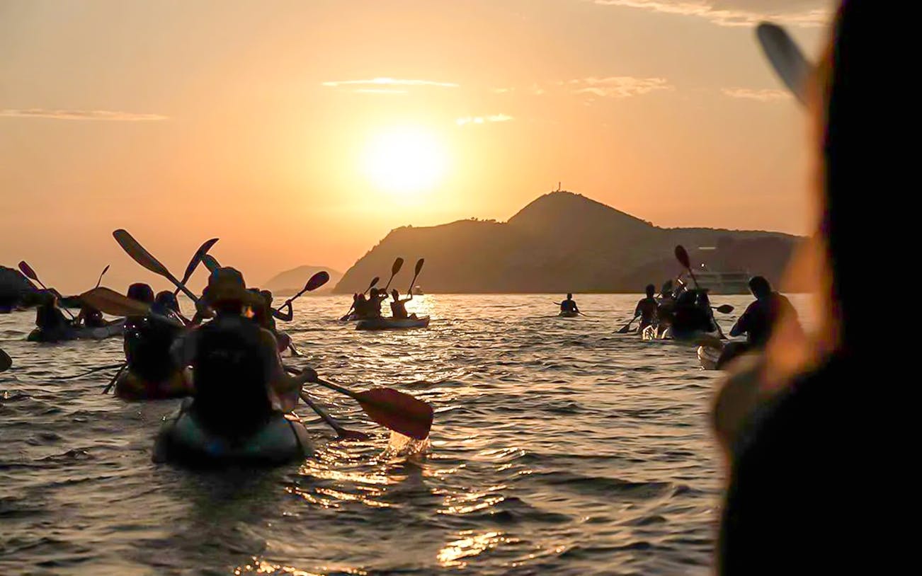 Kayakers paddling at sunset near Dubrovnik.