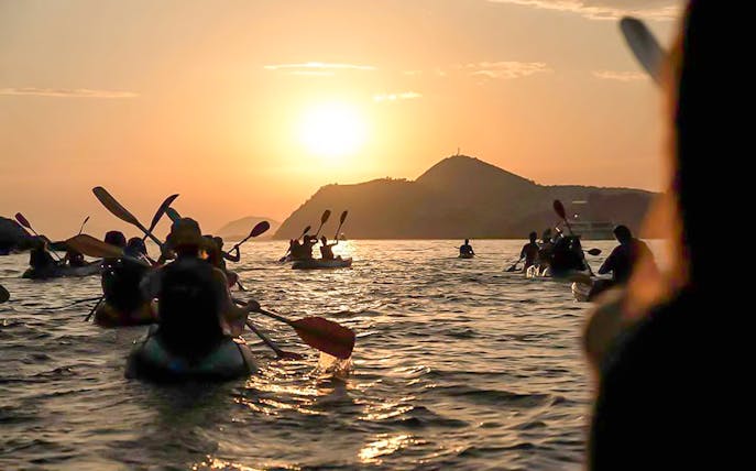 Kayakers paddling at sunset near Dubrovnik.