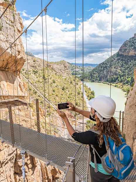 Visitors crossing suspension bridge on Caminito del Rey trail, Málaga, Spain.